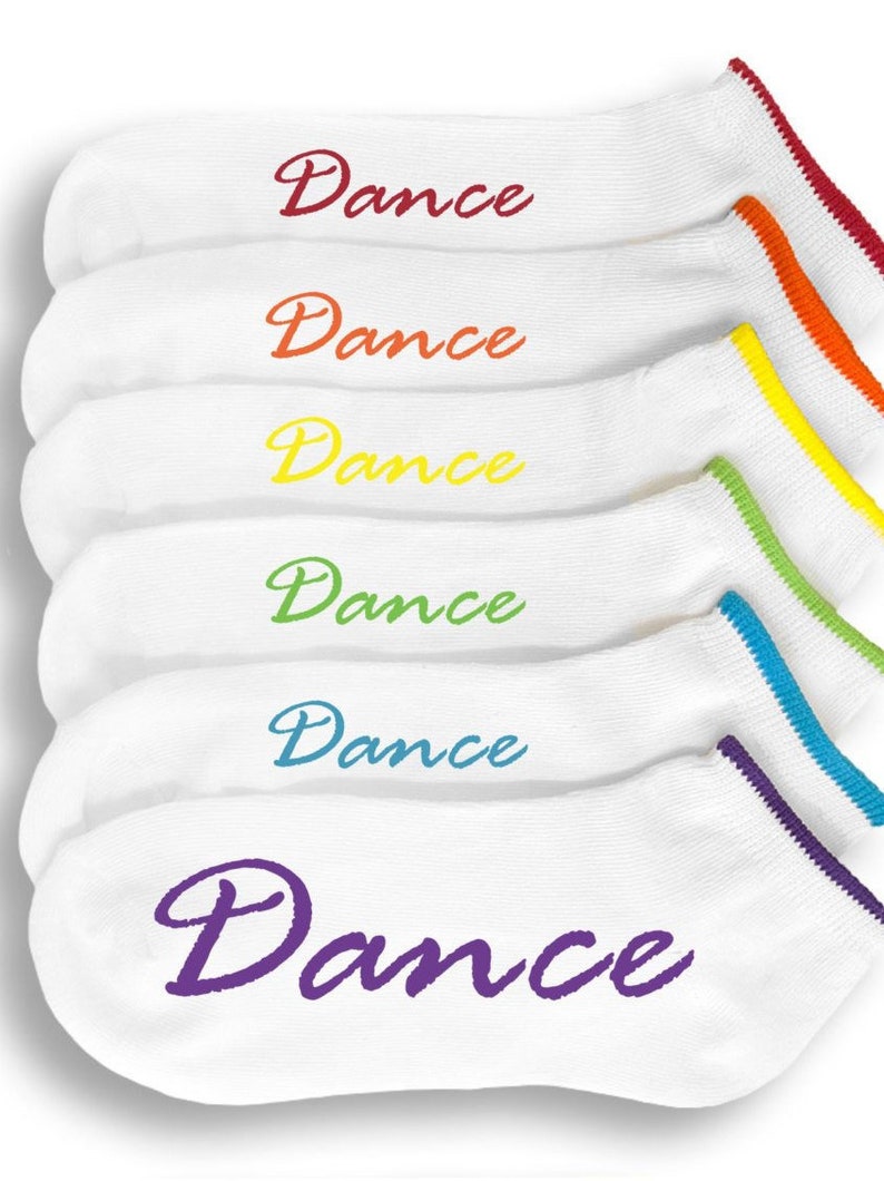 May include: Six pairs of white ankle socks with a colorful trim and the word "Dance" embroidered on each sock in a cursive font.