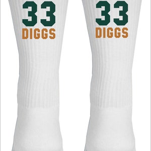 May include: White athletic socks with a green number 33 and the name "DIGGS" in orange lettering.