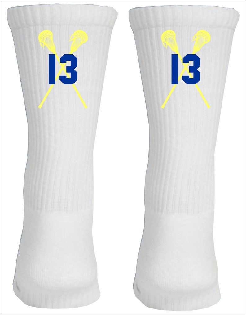May include: A pair of white athletic socks with a yellow lacrosse stick design and the number 13 in blue.