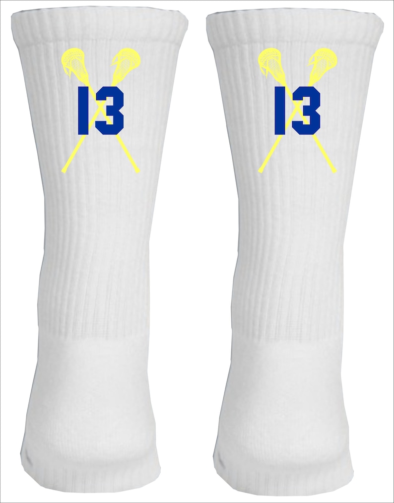 May include: A pair of white athletic socks with a yellow lacrosse stick design and the number 13 in blue.