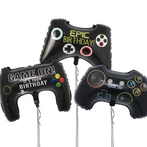 May include: Three black foil balloons shaped like video game controllers. One balloon says "GAME ON! IT'S YOUR BIRTHDAY" and another says "EPIC BIRTHDAY!". The third balloon has the words "GAME ON!" and colorful buttons.
