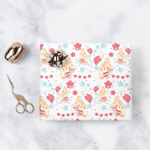 May include: White wrapping paper with a repeating pattern of cute cartoon foxes wearing Santa hats and holding presents. The foxes are surrounded by red and blue stars, candy canes, and a string of white lights.