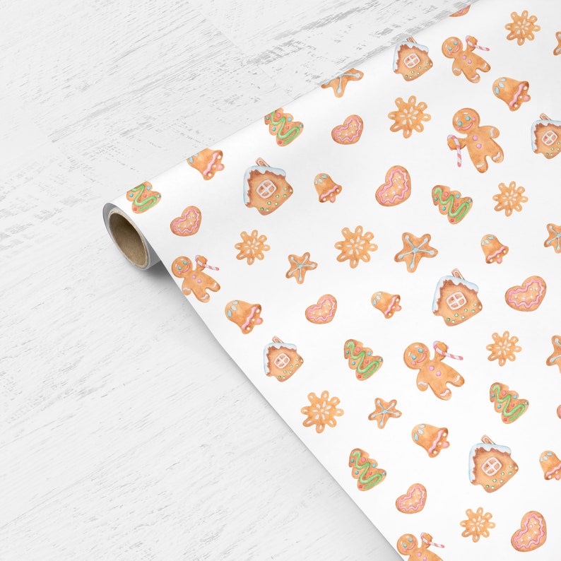 May include: White wrapping paper with a repeating pattern of gingerbread cookies, including gingerbread houses, stars, snowflakes, bells, and Christmas trees. The cookies are decorated with icing and sprinkles.
