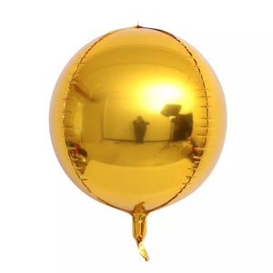 Może przedstawiać: Duży, okrągły, złoty balon. Balon jest wykonany z folii mylarowej i ma błyszczącą, odblaskową powierzchnię.