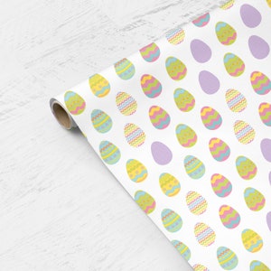 May include: White wrapping paper with a repeating pattern of colorful Easter eggs. The eggs are decorated with different patterns, including polka dots, stripes, and zigzags.