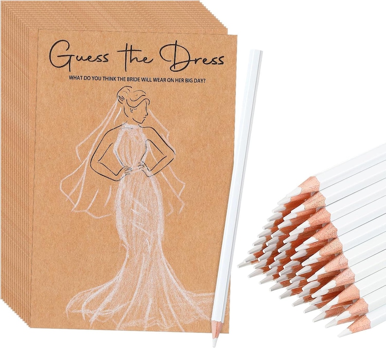 May include: A stack of brown kraft paper cards featuring the black text Guess the Dress and What do you think the bride will wear on her big day? with a white line drawing of a bride in a gown and veil, accompanied by white pencils.