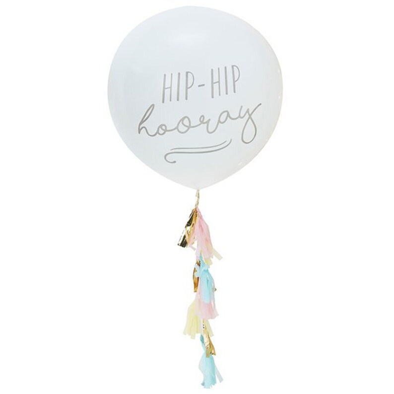 K&ouml;nnte beinhalten: Wei&szlig;er Ballon mit dem Text "Hip-Hip Hooray" in silberner Schrift. Der Ballon hat eine Schnur mit bunten Seidenpapier-Quasten am Boden.