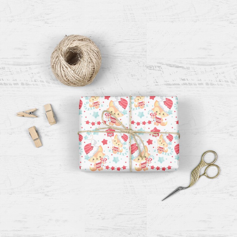 May include: A white gift wrap with a repeating pattern of cute foxes wearing Santa hats and holding presents. The foxes are surrounded by red stars, candy canes, and a red and white garland.
