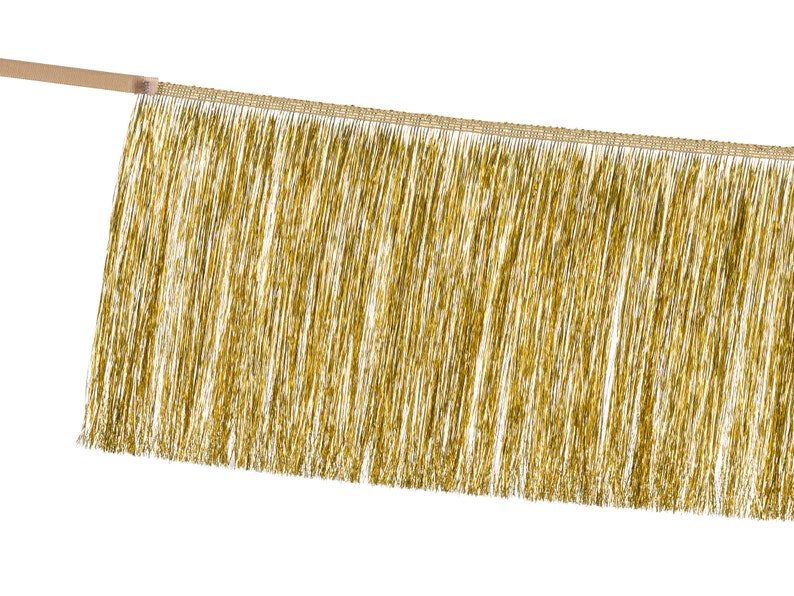 Pu&ograve; includere: Frange dorata con bordo intrecciato. La frangia &egrave; realizzata con sottili fili lucidi di filato metallico.