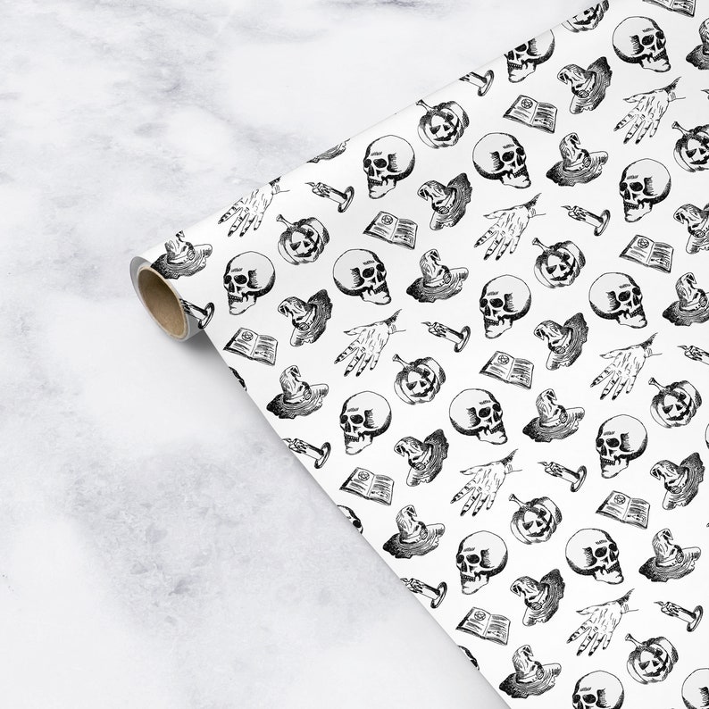 May include: White wrapping paper with a black and white repeating pattern of skulls, pumpkins, witches hats, candles, and hands.