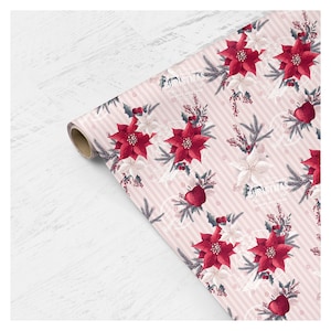 Pode incluir: Papel de embrulho listrado rosa e branco com um padr&atilde;o repetido de flores de poinsettia vermelhas, azevinho verde e ma&ccedil;&atilde;s vermelhas. O papel est&aacute; enrolado e pronto para usar.