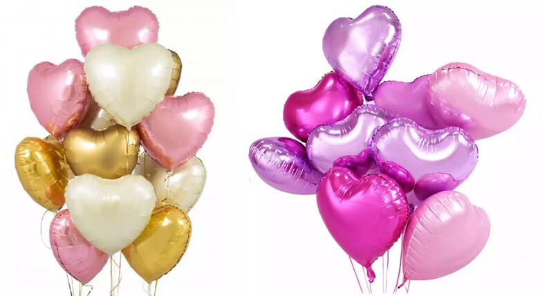 May include: Two bunches of heart-shaped foil balloons. One bunch is pink, gold, and white. The other bunch is purple, pink, and lavender.