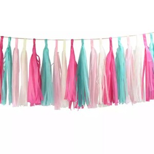 Pode incluir: Guirlanda de borlas coloridas com borlas alternadas em tons de rosa, turquesa e branco. As borlas s&atilde;o suspensas por um fio fino e dourado, criando um elemento festivo e decorativo. Perfeita para festas e celebra&ccedil;&otilde;es.