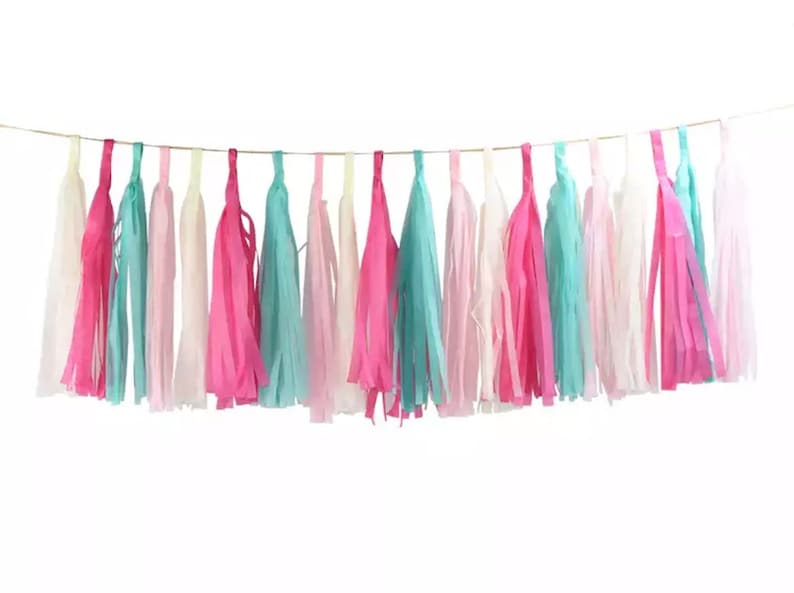 Pode incluir: Guirlanda de borlas coloridas com borlas alternadas em tons de rosa, turquesa e branco. As borlas s&atilde;o suspensas por um fio fino e dourado, criando um elemento festivo e decorativo. Perfeita para festas e celebra&ccedil;&otilde;es.