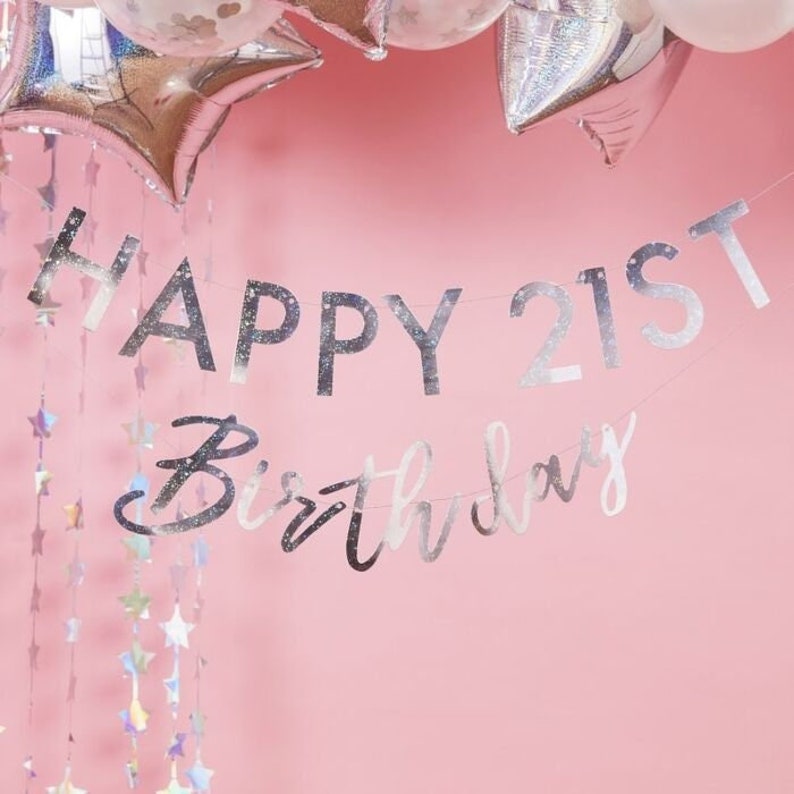 May include: Silver glitter banner with the text "Happy 21st Birthday".