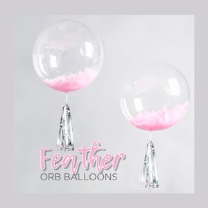 May include: Two clear orb balloons with pink feathers inside and silver streamers hanging from the bottom. The text "Feather Orb Balloons" is written below the balloons.