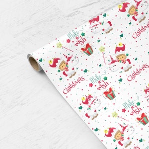 May include: White wrapping paper with a repeating pattern of a unicorn, a girl wearing a red elf hat, and the text "Make a wish" and "Christmas".