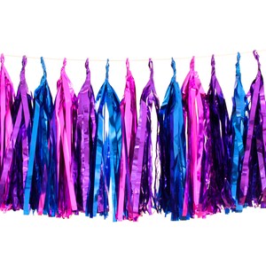 Pode incluir: Uma guirlanda de borlas coloridas para festas em tons de azul, roxo e rosa. As borlas s&atilde;o feitas de material brilhante e met&aacute;lico e est&atilde;o penduradas em um fio fino contra um fundo branco. Ideal para decora&ccedil;&otilde;es de festas.
