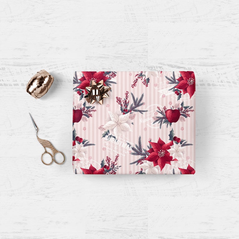 Pode incluir: Papel de embrulho listrado rosa e branco com um padr&atilde;o floral que inclui poinsettias vermelhas, flores brancas, folhas verdes e ma&ccedil;&atilde;s vermelhas. O papel tem o texto "Merry Christmas" impresso.