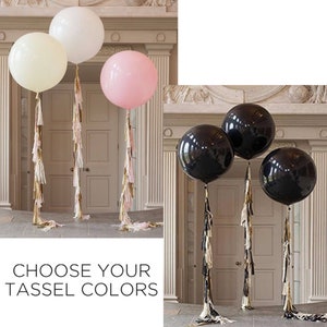 May include: Three large balloons with tassel streamers. The balloons are white, pink, and black.  Choose your tassel colors.