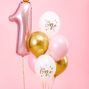 Pu&ograve; includere: Palloncini rosa, bianchi e dorati con la scritta "one". Un palloncino rosa a forma di numero uno ha una corona dorata in cima.