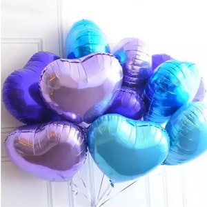 May include: A bunch of heart-shaped balloons in shades of blue and purple. The balloons are metallic and have a shiny finish.