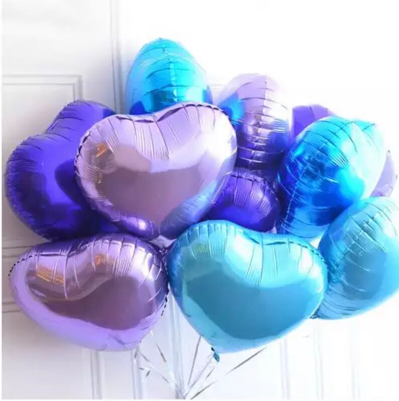 May include: A bunch of heart-shaped balloons in shades of blue and purple. The balloons are metallic and have a shiny finish.