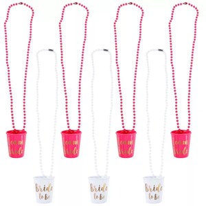 Pu&ograve; includere: Set di sei collane di perline rosa e bianche con bicchieri di plastica attaccati. I bicchieri rosa hanno una scritta dorata che dice "Team Bride". I bicchieri bianchi hanno una scritta dorata che dice "Bride to Be".