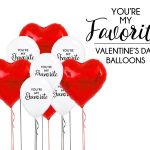 May include: A set of red and white heart-shaped balloons with the text "You're My Favorite" printed on them. Valentine's Day balloons.