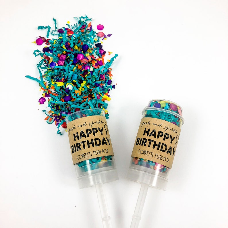Op de afbeelding: Twee confetti push-pops met bruine papieren etiketten waarop staat "posh and sparkle HAPPY BIRTHDAY CONFETTI PUSH-POP". De confetti is turquoise, oranje, roze en geel.