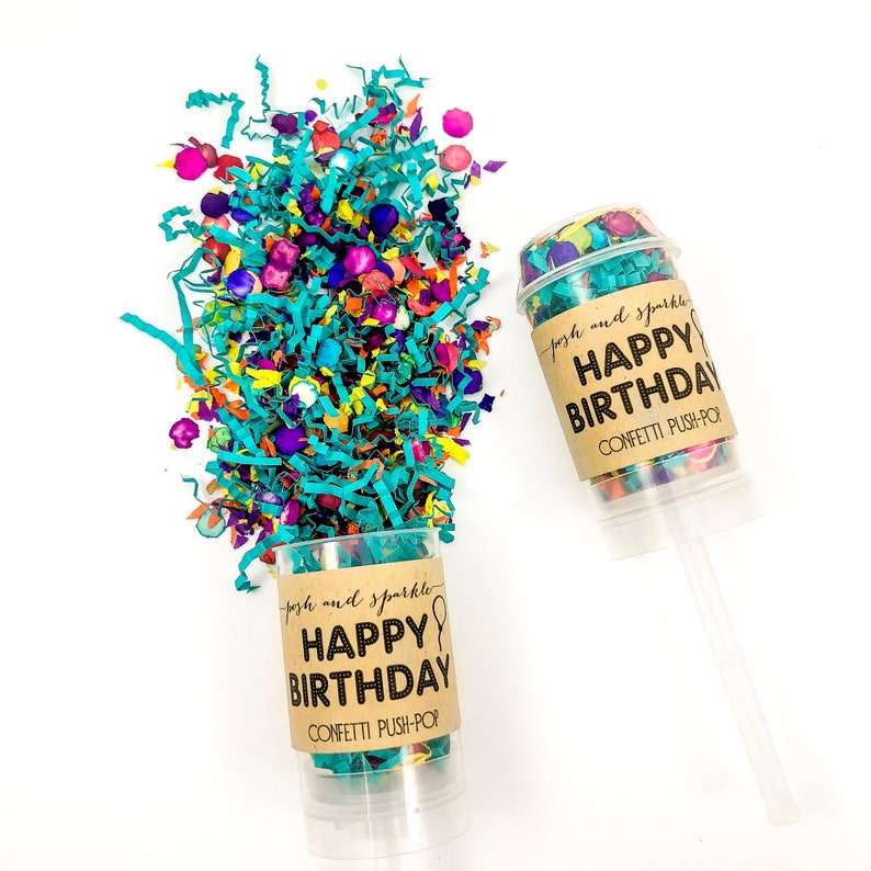 Op de afbeelding: Twee confetti push-pops met bruine labels waarop staat "posh and sparkle HAPPY BIRTHDAY CONFETTI PUSH-POP". E&eacute;n push-pop staat rechtop en de andere ligt ondersteboven met confetti die eruit valt.
