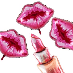 May include: Three pink and red foil balloons shaped like lips and a lipstick. The lips are shiny and have a white outline. The lipstick is shiny and has a gold glitter detail.