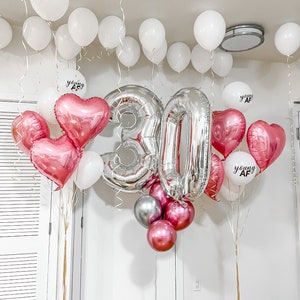 Może przedstawiać: Srebrne balony z numerem 30, r&oacute;żowe balony w kształcie serca i białe balony z napisem "young AF".