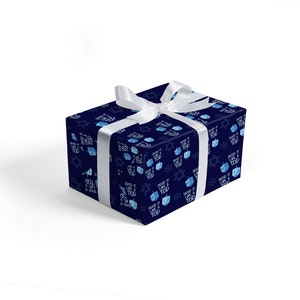 May include: A blue gift wrap with a white ribbon. The wrapping paper has a repeating pattern of blue dreidels and the text "Spin it like a top".