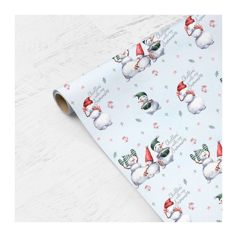 May include: Blue wrapping paper with a repeating pattern of snowmen wearing hats and scarves. The text "Chillin' with my snowmies" is repeated throughout the pattern.