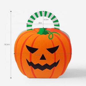 May include: An orange pumpkin-shaped paper gift box with a black jack-o'-lantern face, a green stem, and a green and white striped handle. The box measures 18.5 cm in total height, 15.7 cm in width, with a 9 cm wide and 4.7 cm high handle opening.