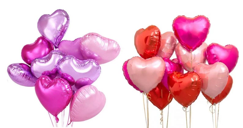May include: A bouquet of heart-shaped balloons in shades of pink, purple, and red. The balloons are tied together with ribbons and are floating in the air.
