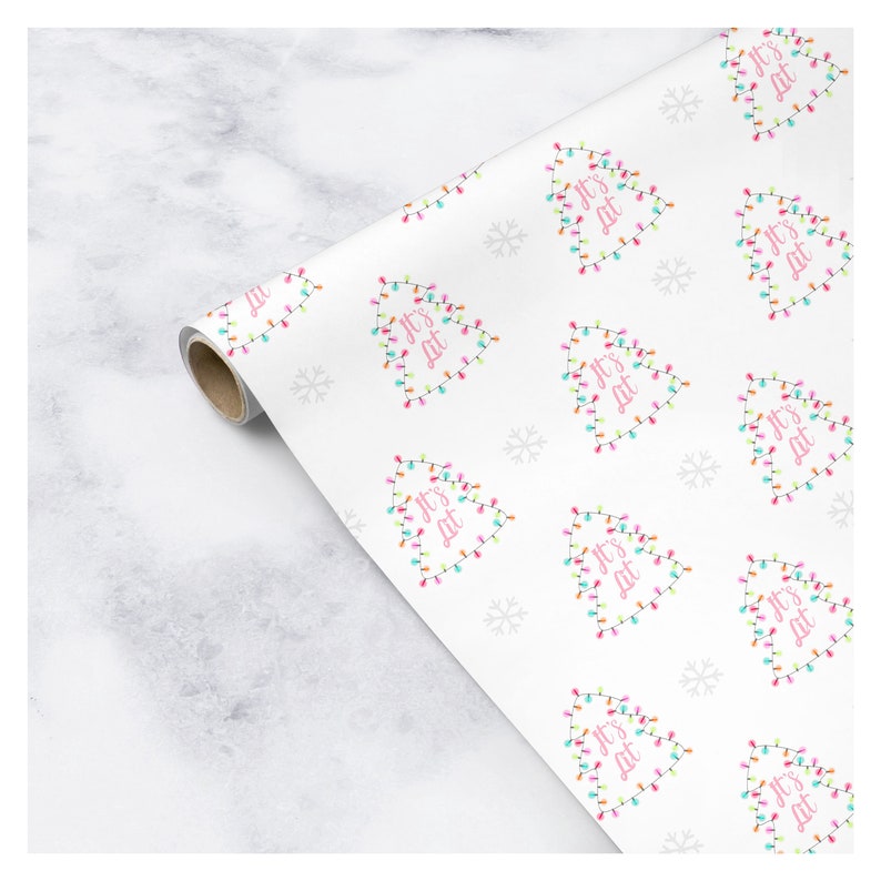 May include: White wrapping paper with a repeating pattern of Christmas trees decorated with colorful lights. The trees have the text "It's Lit" written on them.