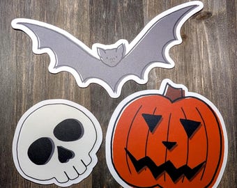 Paquete de 3 pegatinas con diseños de murciélagos, calaveras y calabazas de Halloween.
