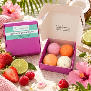 Könnte beinhalten: Eine violette Pappschachtel mit vier runden Badekugeln in Pink, Orange und Weiß. Der Deckel trägt den Text Kleine Auszeit Badekugeln Sommerfrische, während im Inneren die Duftrichtungen Erdbeer-Rhabarber, Pina Colada, Tropicana und Blütenfrische aufgeführt sind.