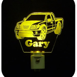 May include: A yellow illuminated night light with a silhouette of a pickup truck and the name "Gary" underneath.