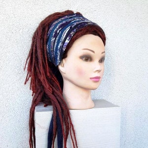 May include: A blue and purple patterned headband with a white background. The headband is worn on a mannequin with long, red dreadlocks.