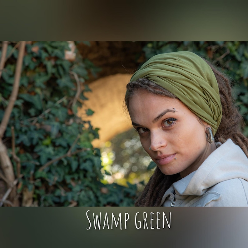 May include: A swamp green fabric headband featuring a gathered, twisted design that wraps around the head. The text SWAMP GREEN is printed in white at the bottom of the image. The headband is made of a soft, solid-colored material.