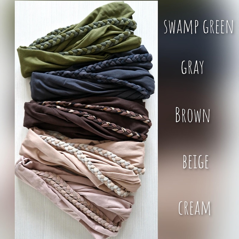 May include: A stack of five fabric headbands in swamp green, gray, brown, beige, and cream. Each headband features a braided fabric detail across the front. The colors are labeled on the right side as SWAMP GREEN, GRAY, BROWN, BEIGE, and CREAM.