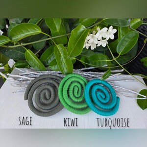 Puede incluir: Tres bobinas en forma de espiral envueltas en tela dispuestas horizontalmente. Las bobinas son de color salvia, kiwi y turquesa, con las etiquetas 'SAGE', 'KIWI' y 'TURQUOISE' impresas en negro debajo de cada una de ellas.