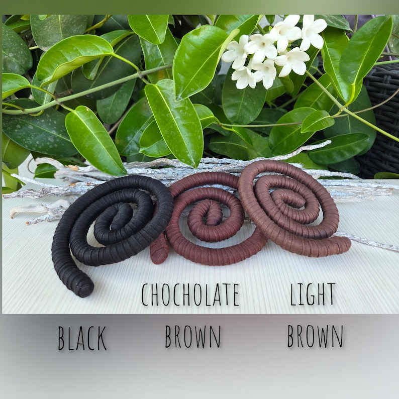 Puede incluir: Tres objetos en forma de espiral enrollada dispuestos horizontalmente. La espiral de la izquierda es negra, la del centro es marr&oacute;n chocolate y la de la derecha es marr&oacute;n claro. El texto indica BLACK, CHOCHOLATE BROWN y LIGHT BROWN.