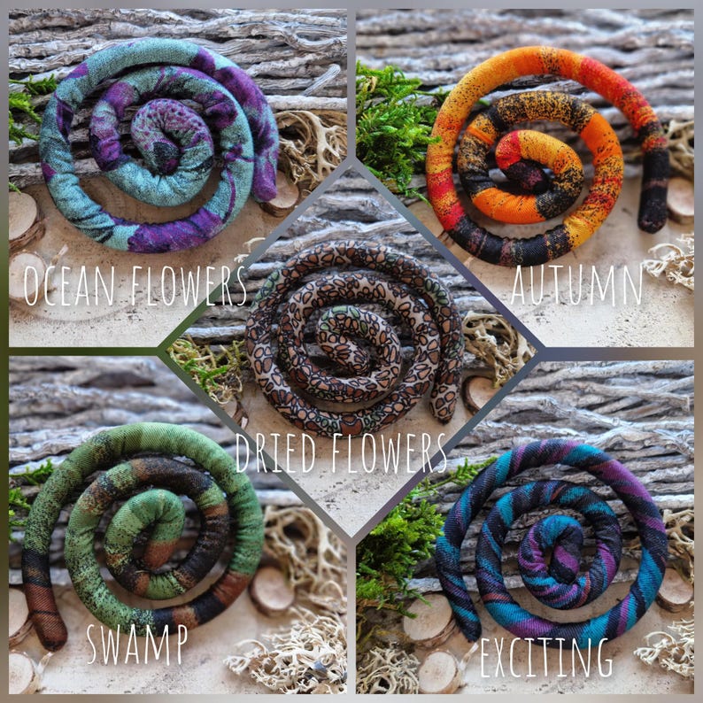 May include: Five spiral-shaped fabric hair accessories in various colors and patterns. The Ocean Flowers style is teal and purple, Autumn is orange and black, Dried Flowers is brown with floral prints, Swamp is green and brown, and Exciting is blue and purple.