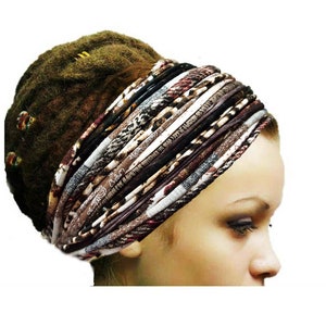 May include: A wide, multi-layered fabric headband featuring a variety of brown, black, white, and grey patterns, including animal prints and textured stripes. The accessory is wrapped around the head, showcasing a complex, layered design.