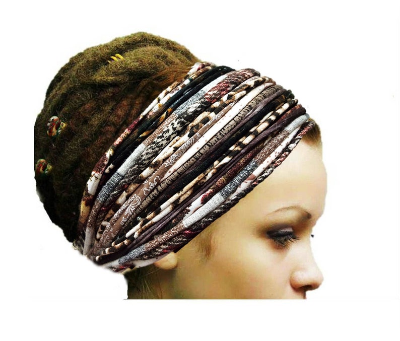 May include: A wide, multi-layered fabric headband featuring a variety of brown, black, white, and grey patterns, including animal prints and textured stripes. The accessory is wrapped around the head, showcasing a complex, layered design.