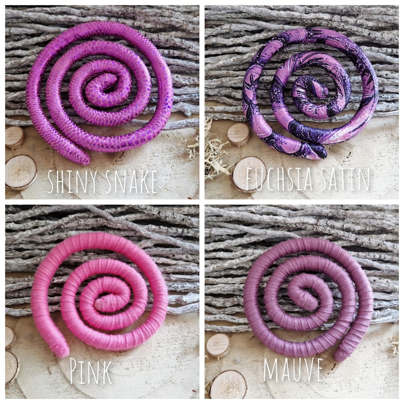Pu&ograve; includere: Quattro accessori per capelli a forma di spirale disposti in una griglia. In alto a sinistra, fucsia lucido con texture a serpente; in alto a destra, raso fucsia con motivi neri; in basso a sinistra, tessuto rosa tinta unita; in basso a destra, tessuto color malva tinta unita.